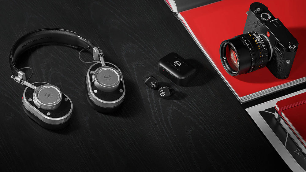 There are black old camera, black earphones, black and steel colored headphones.